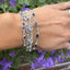 Sterling silver bracelets set with purple and blue gemstones, worn on a wrist
